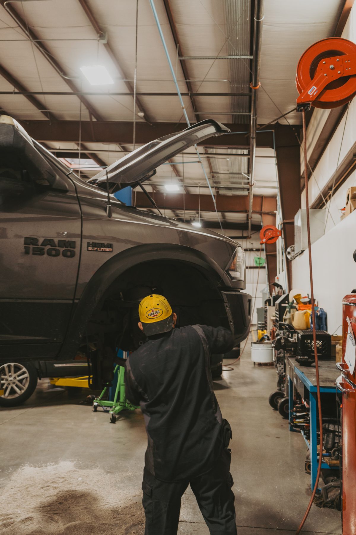 Mechanic inspecting the front brake assembly of a Ram 1500 during brake repair service
